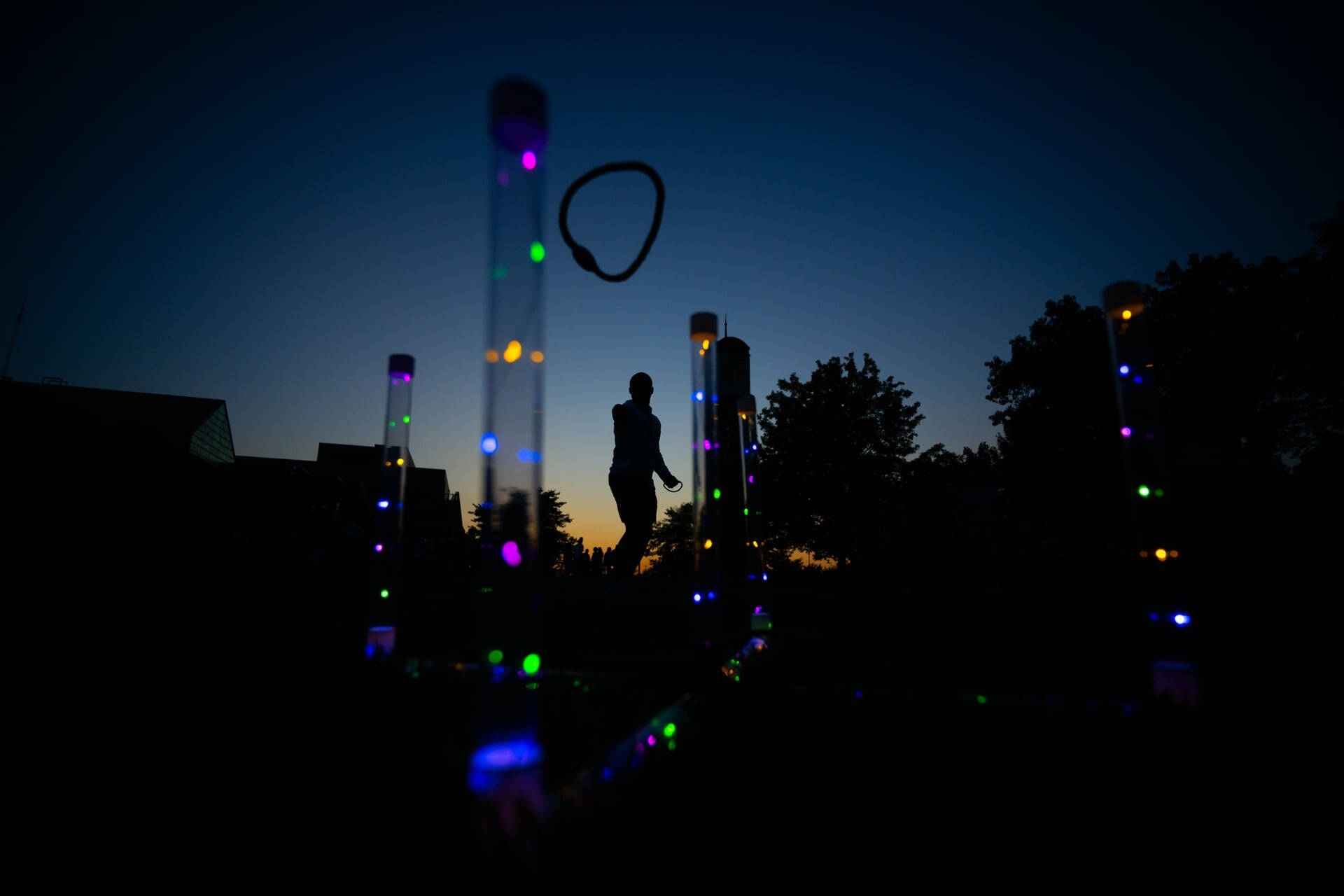 at night, a student tosses rings during a game on the Kirkhof Center lawn